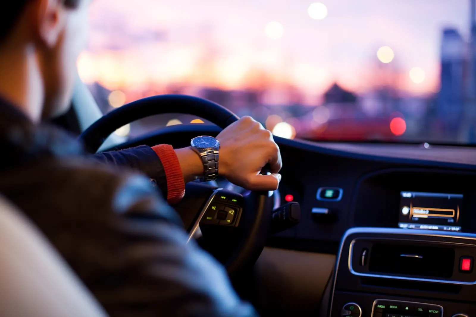 Una persona conduciendo al volante al atardecer