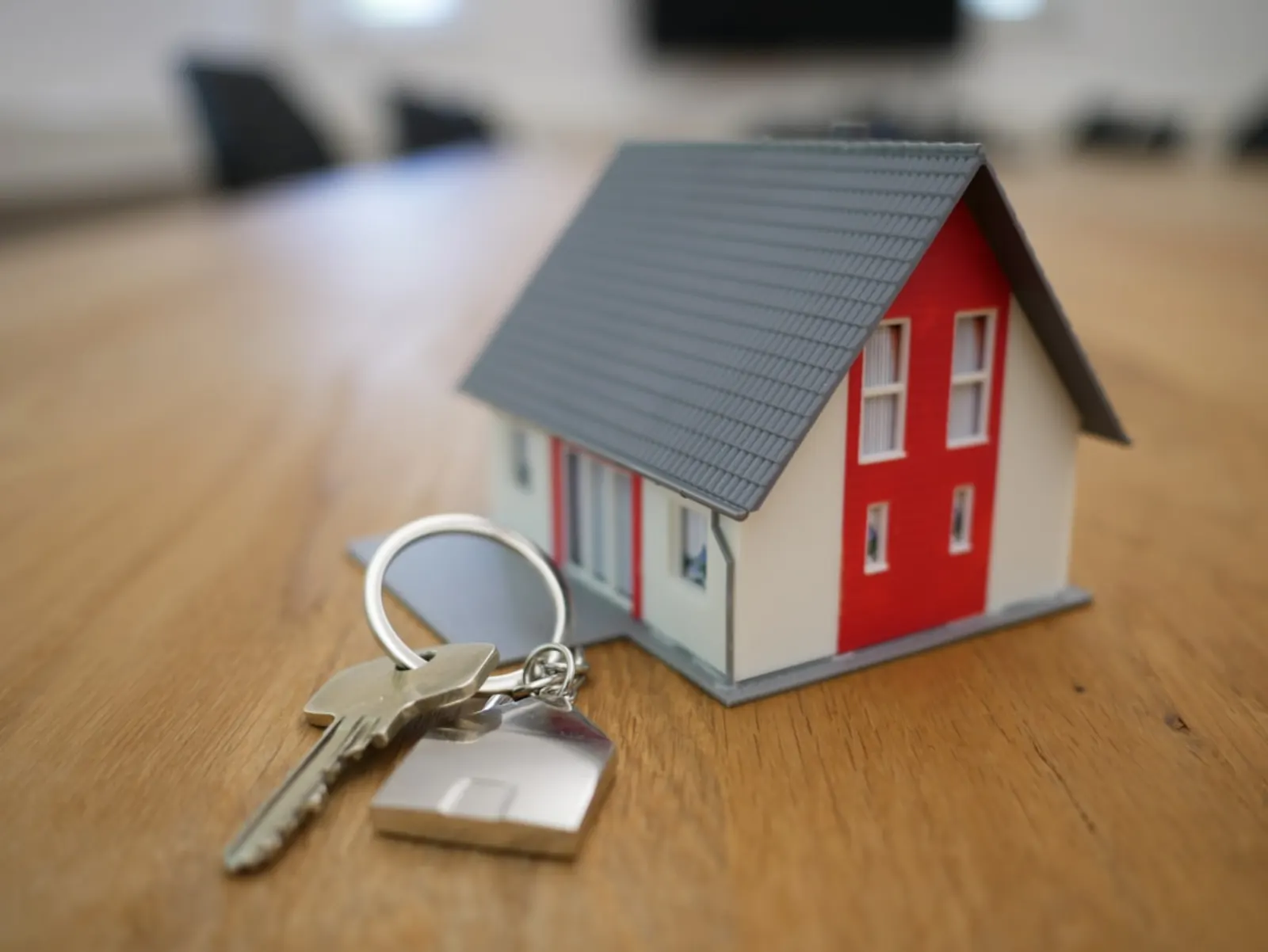 Model house and keys on a desk