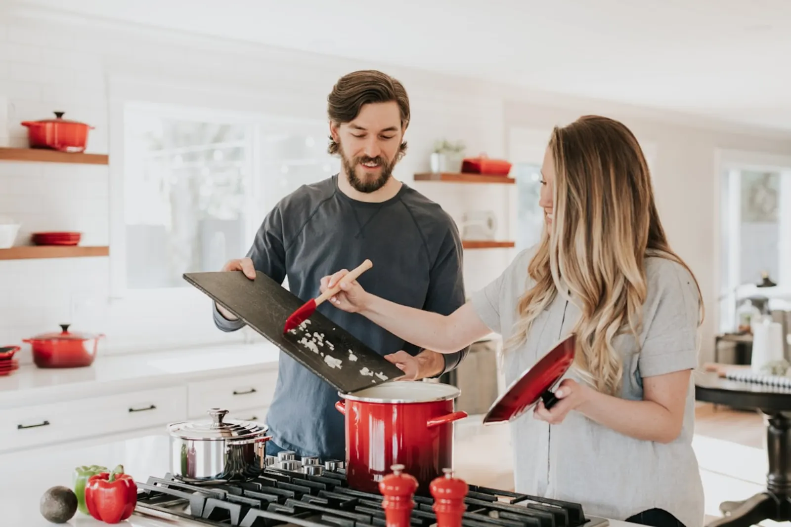 A couple cooking together in a bright kitchen